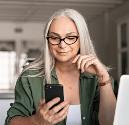 Woman smiling and looking down at her smartphone