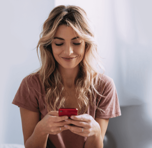 Woman smiling looking down at her smartphone